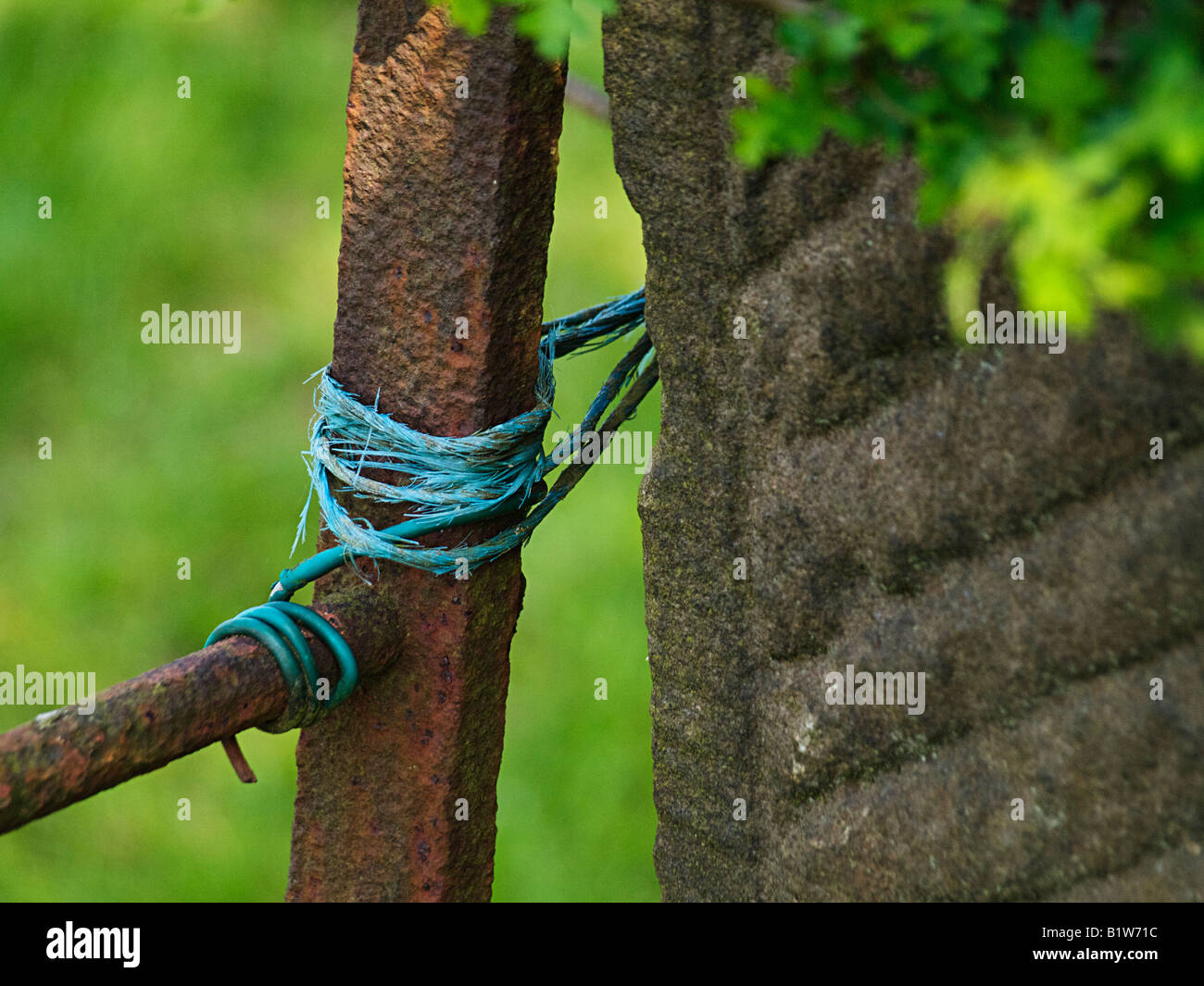 A rusty gate held closed with string Stock Photo - Alamy