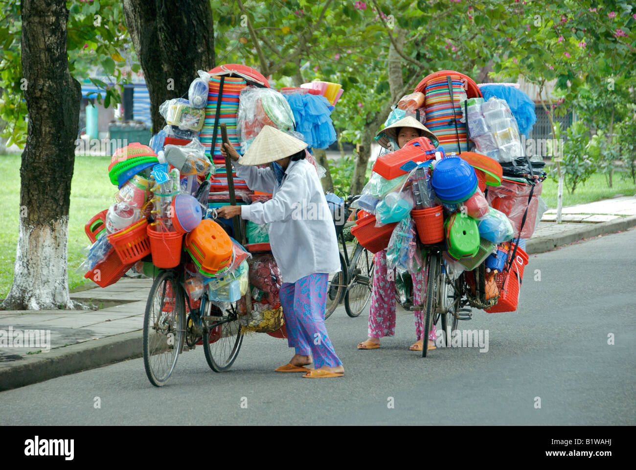 Two women traders with loaded bicycles going to market Hue Vietnam Stock Photo