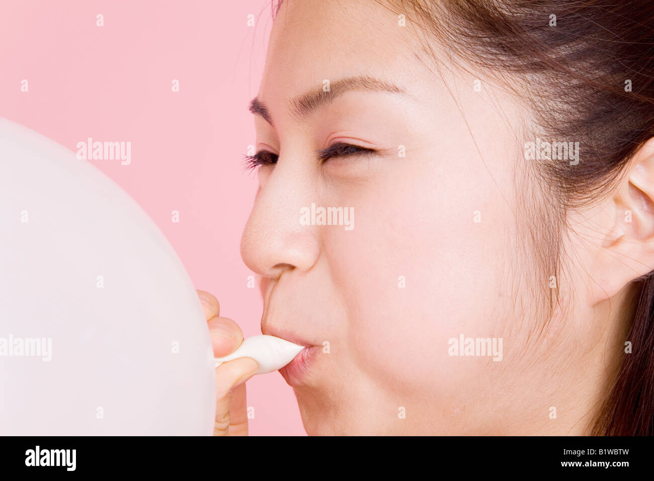 Japanese young woman blowing up a balloon Stock Photo