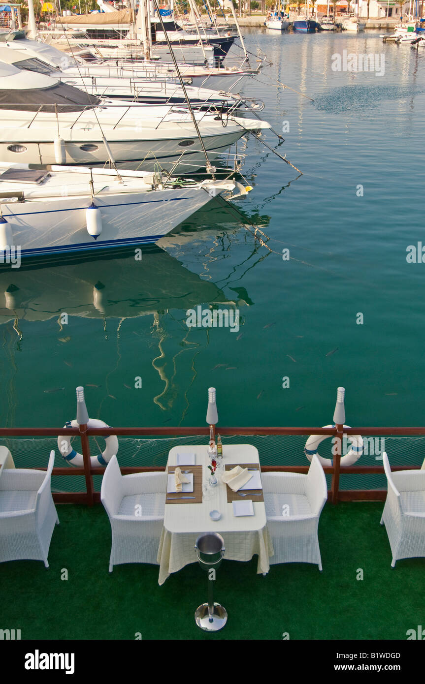 A table set up ready for dinner at an exclusive waterside restauarant in the Yasmine Hammamet marina, Tunisia. Stock Photo