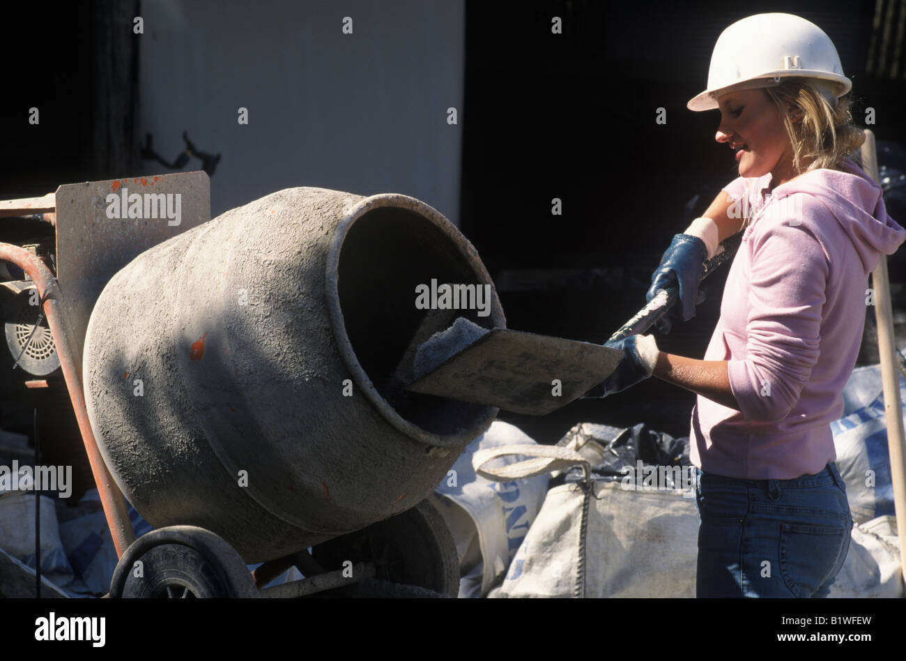 female builder mixing cement Stock Photo