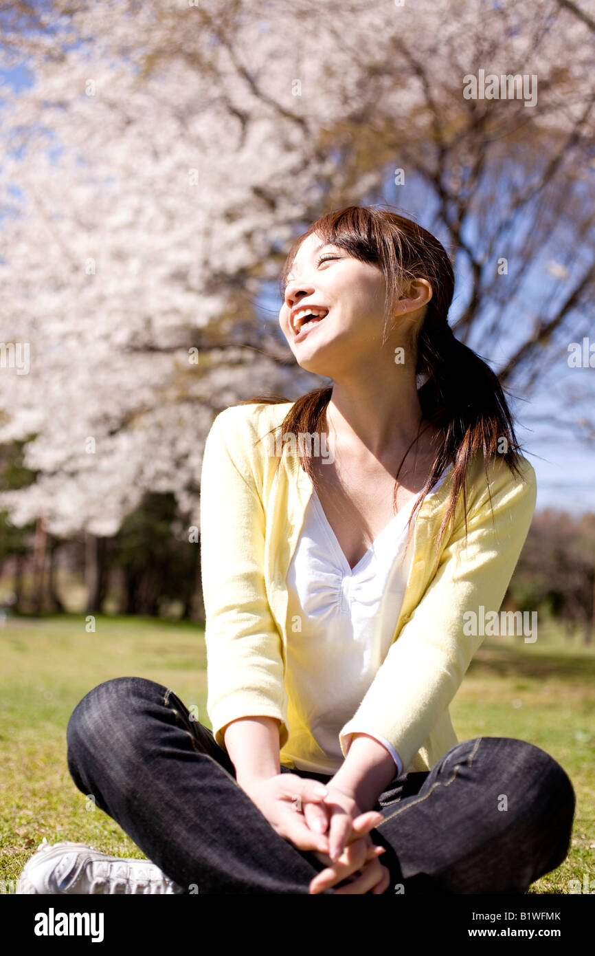 Japanese young woman sitting on the ground Stock Photo - Alamy