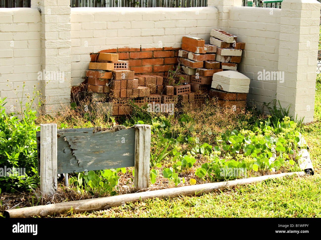 A pile of bricks in front of a white brick wall Stock Photo