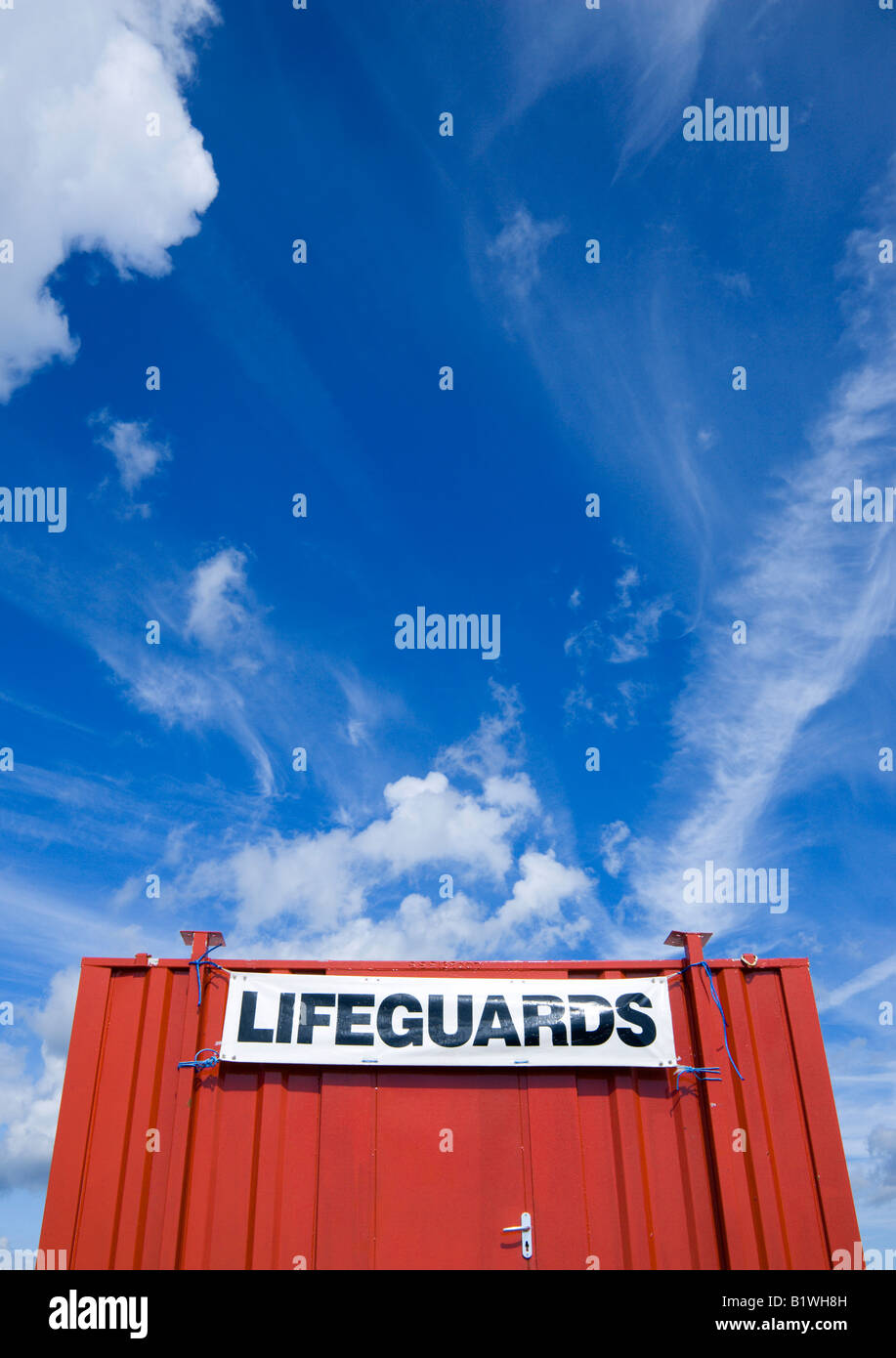 ENGLAND West Sussex Littlehampton Red shipping container used as a lifeguards hut on the beach with expansive blue sky overhead Stock Photo