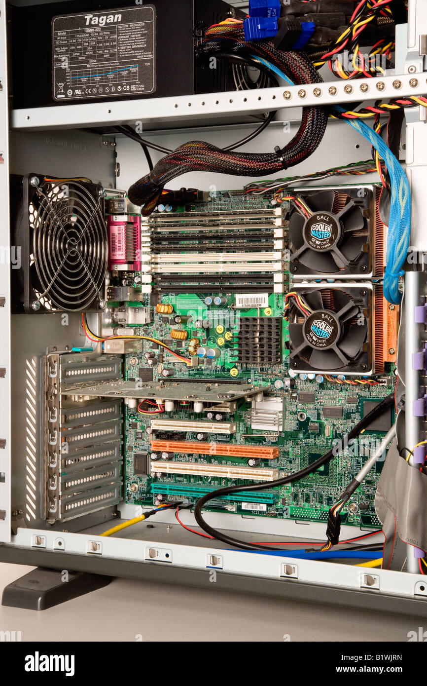 INDUSTRY Machines Computers Interior of desktop PC with power unit mother board fans processors cables PCI memory card clots Stock Photo