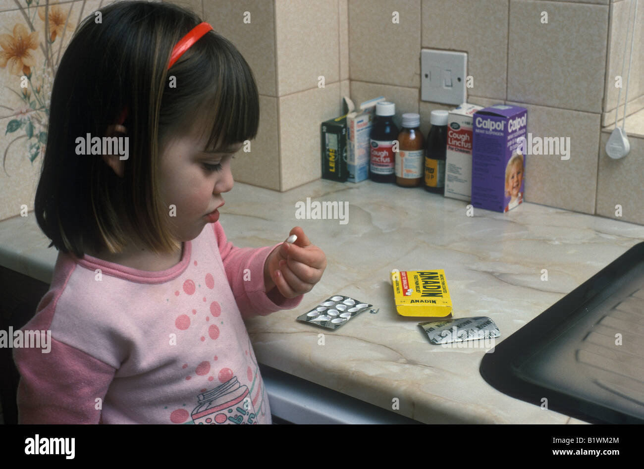 Young girl looking at Anadin pills Stock Photo