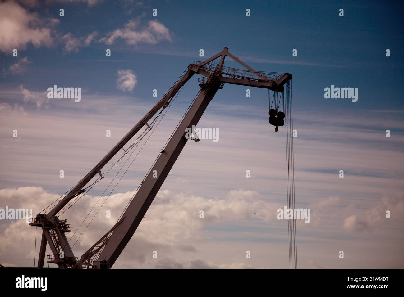 Huge dock crane against a cloudy blue sky Stock Photo - Alamy