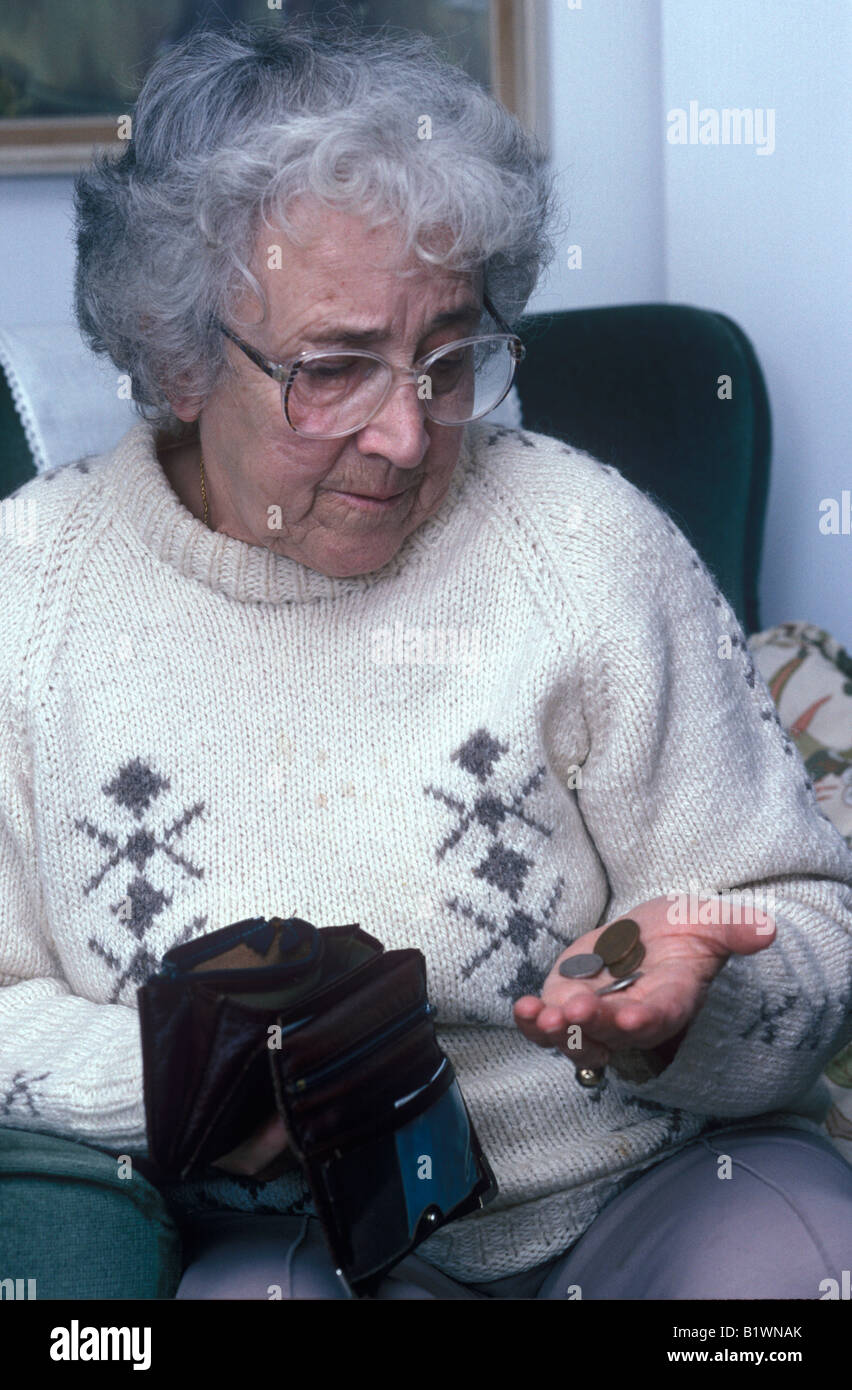 elderly woman looking at the coins in her purse Stock Photo