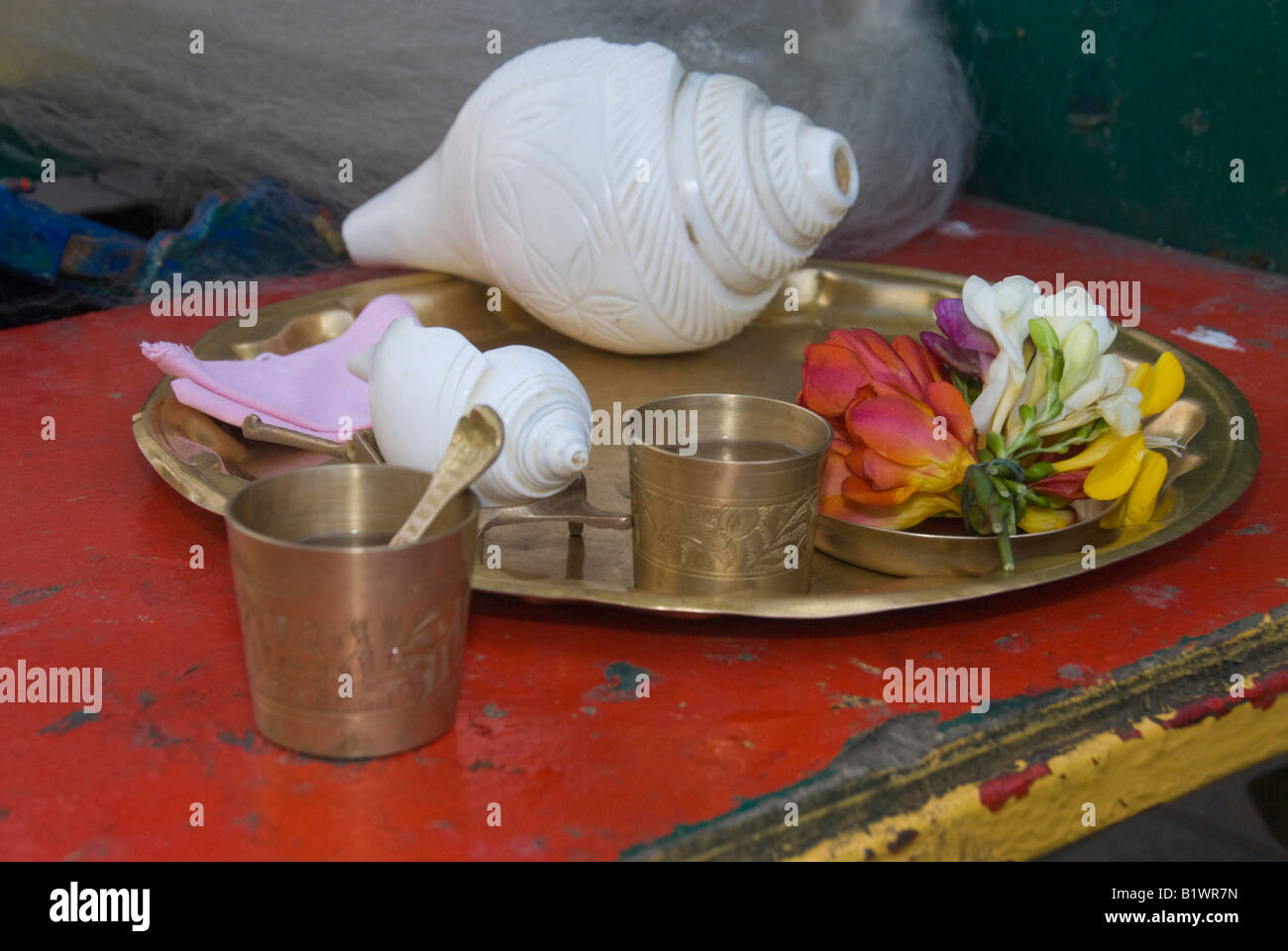 Blossoms, a shell and bass dish and cups at Hare Krishna Guara Purnima ceremony in London Stock Photo
