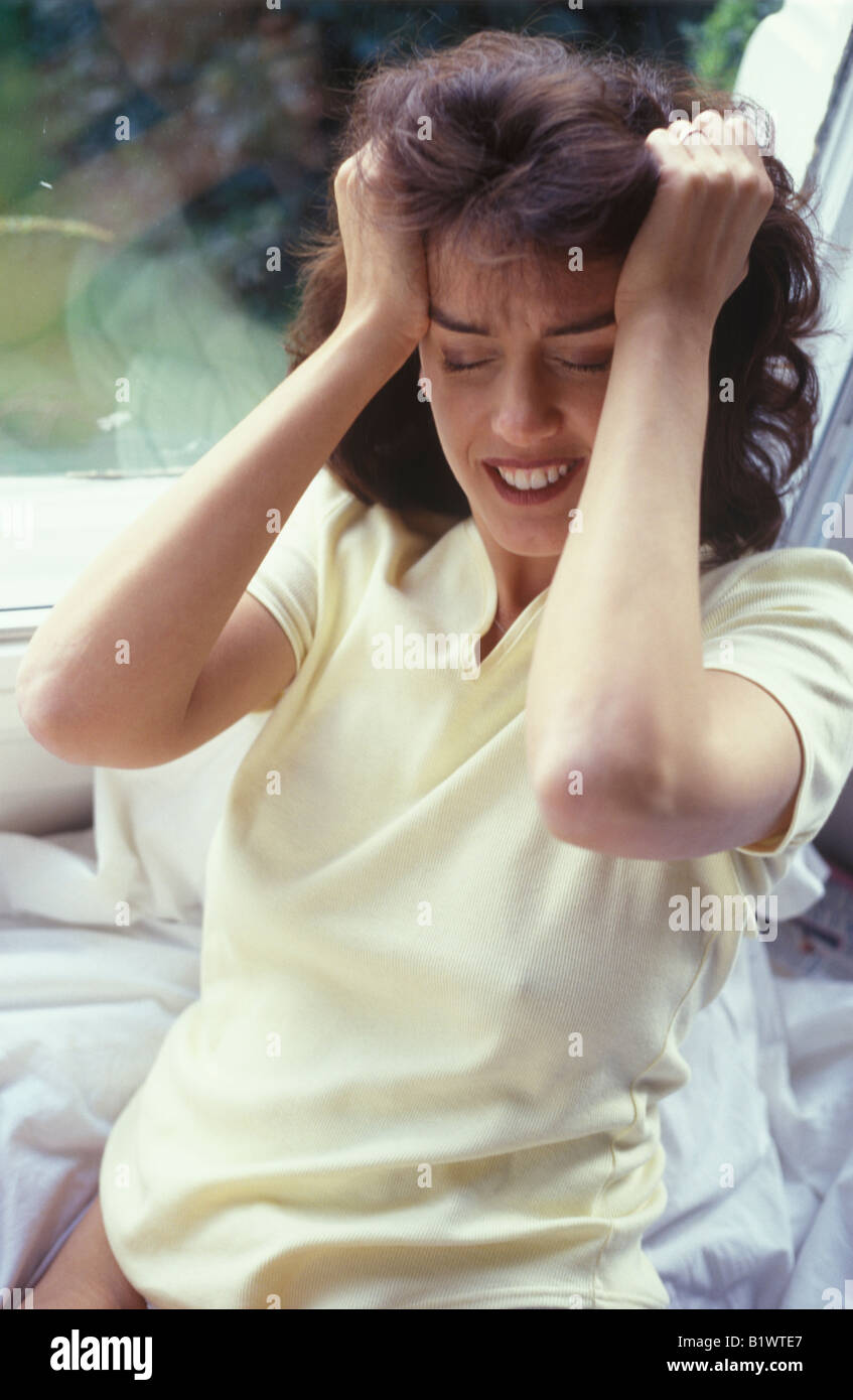 stressed woman holding her head Stock Photo