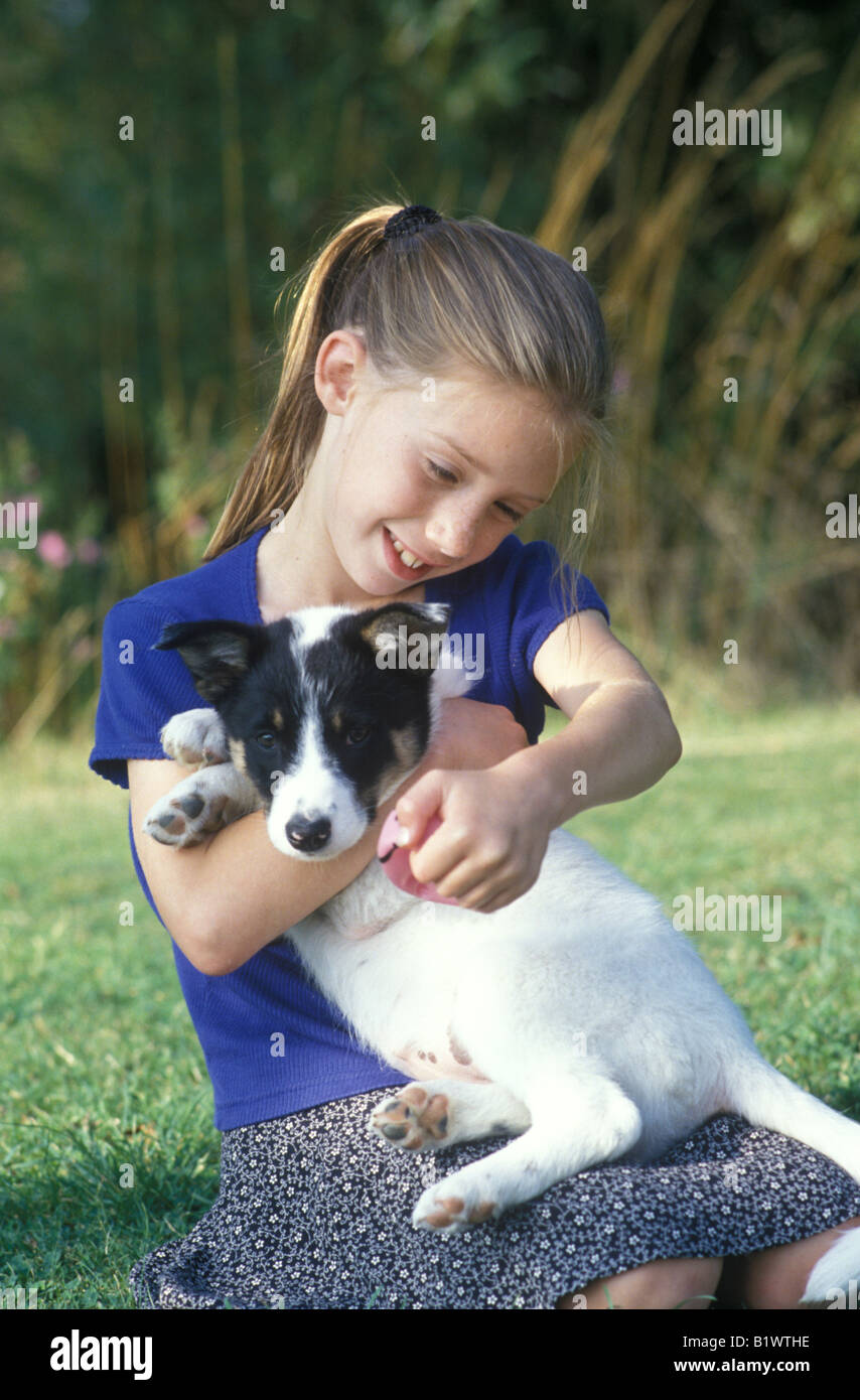 little girl playing with a puppy in the garden Stock Photo - Alamy
