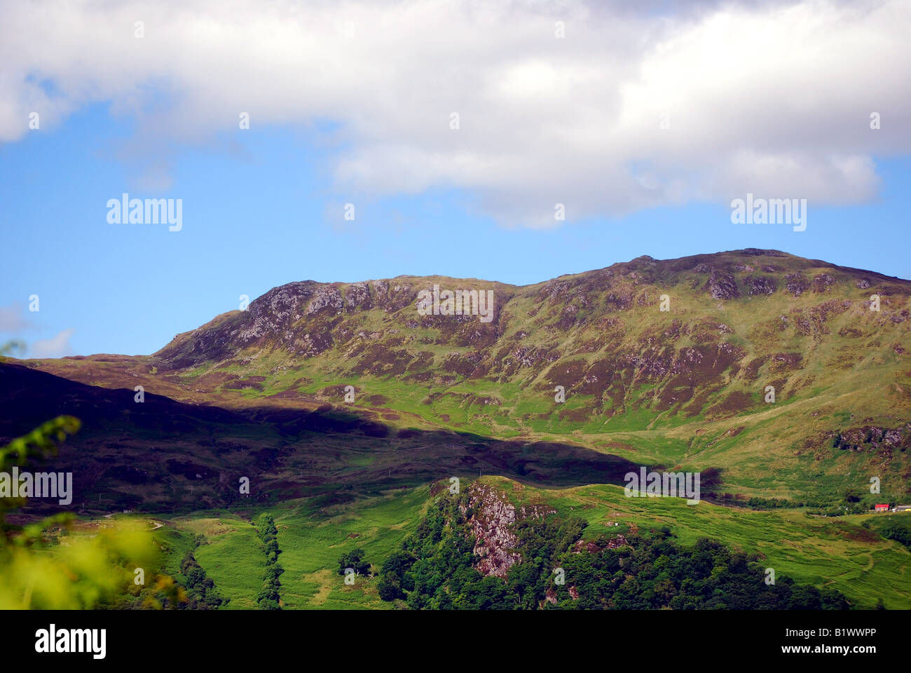 Scotlands highlands.  A large shadow is cast over the tall range accross the loch. Stock Photo