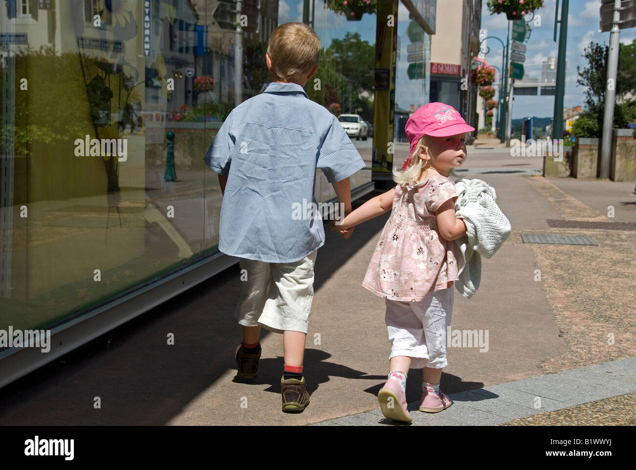 Stock photo of a young child walking hand in hand with his younger ...