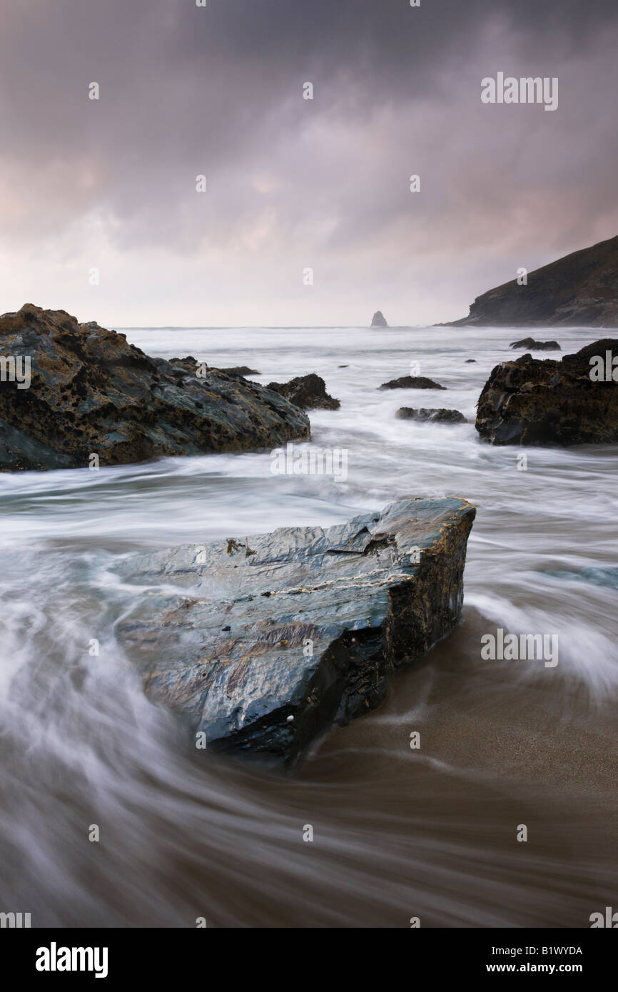 Incoming tide swirling around rocks on Tregardock Beach North Cornwall England Stock Photo