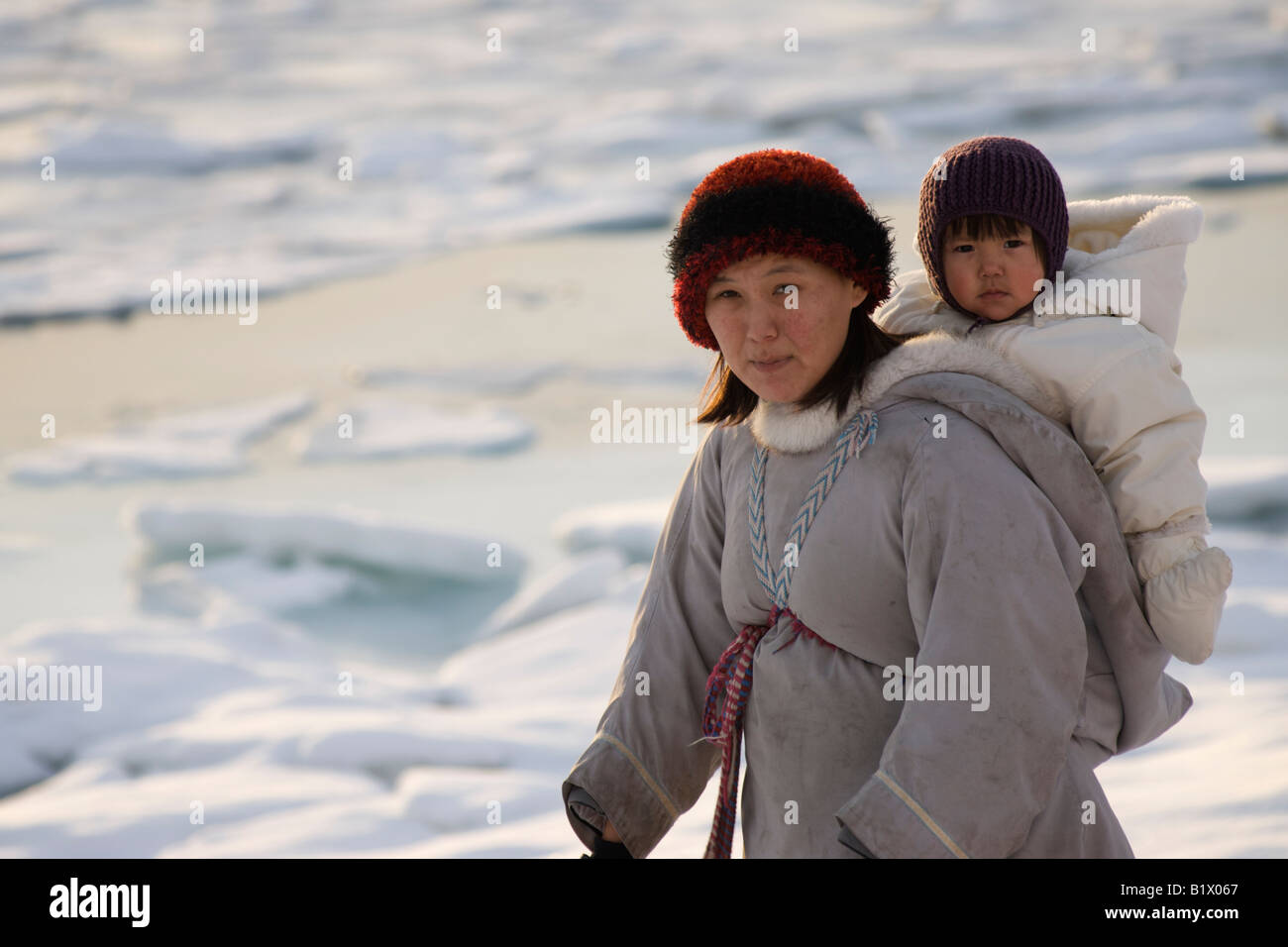 Inuit woman with her baby in traditional Amauti dress in North Americas furthest northern community Grise Fiord. Stock Photo