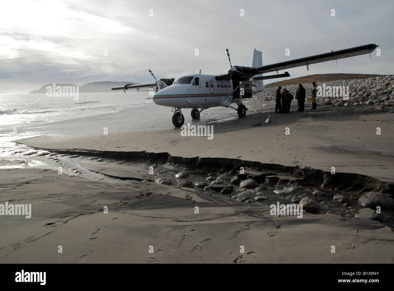 Twin Otter DHC-6 on a beach picking up scientists at low tide in Taloyoak fiord, Nunavut, Canada.  Canadian Arctic. Stock Photo