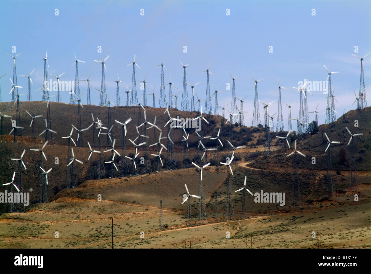 wind energy wind power wind wheel turbine beside highway in California blue sky and open space Stock Photo