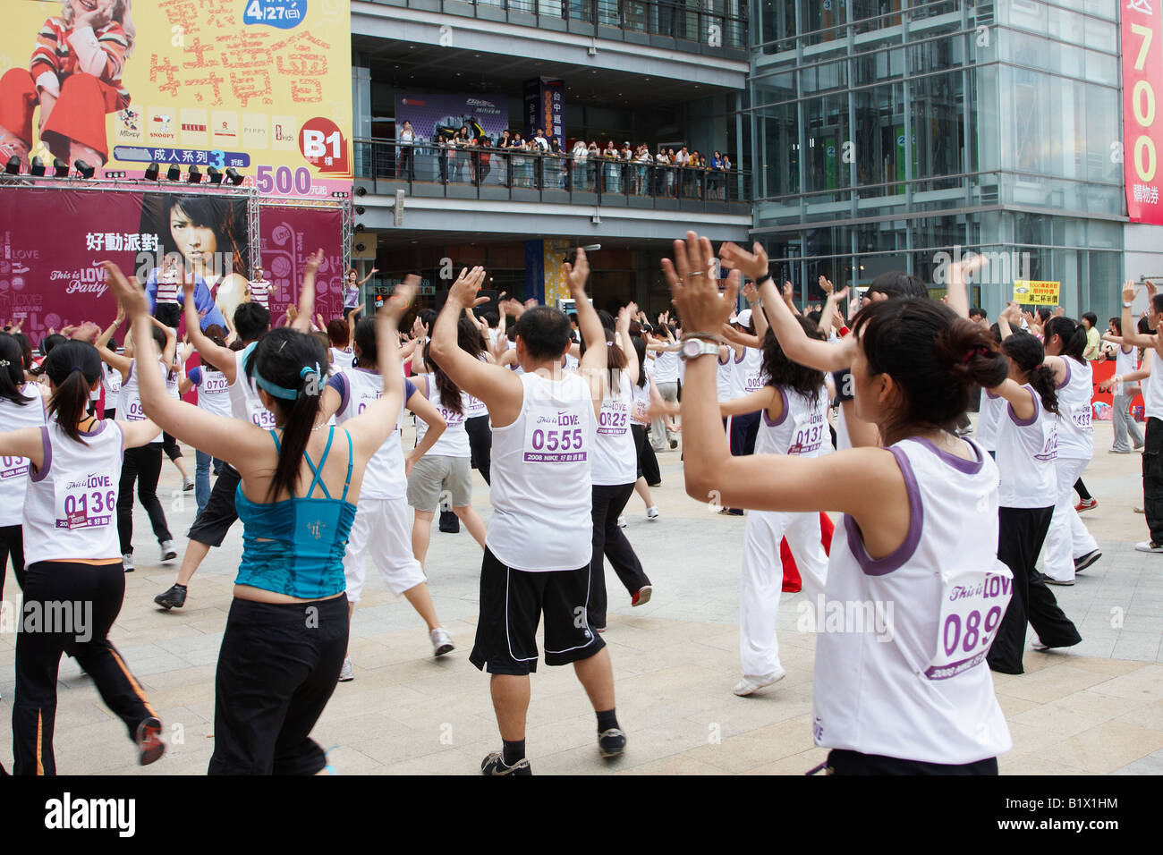 Crowd Of Taiwanese People Following Instructors Doing Aerobic Exercises Stock Photo