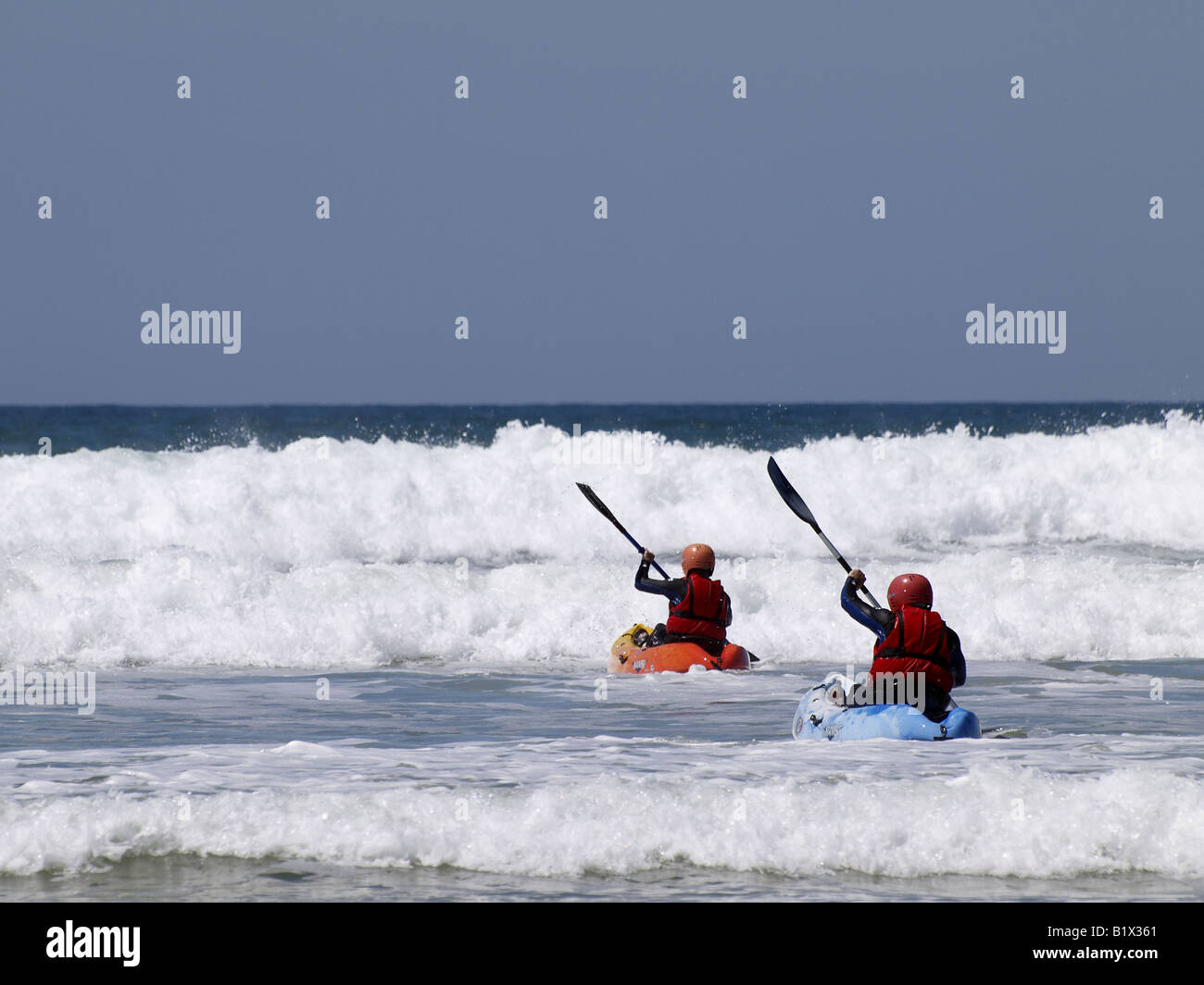 Two surf ski canoeists heading into the waves. Westward Ho! Devonshire, UK Stock Photo