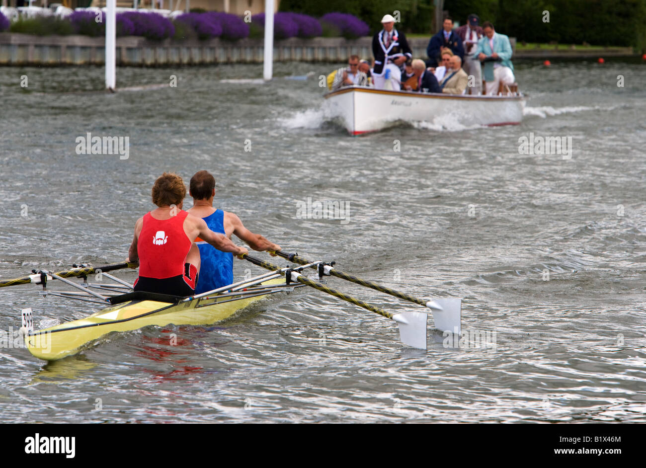 two competitive rowers on the River Thames followed by umpires at Henley Royal Regatta Stock Photo