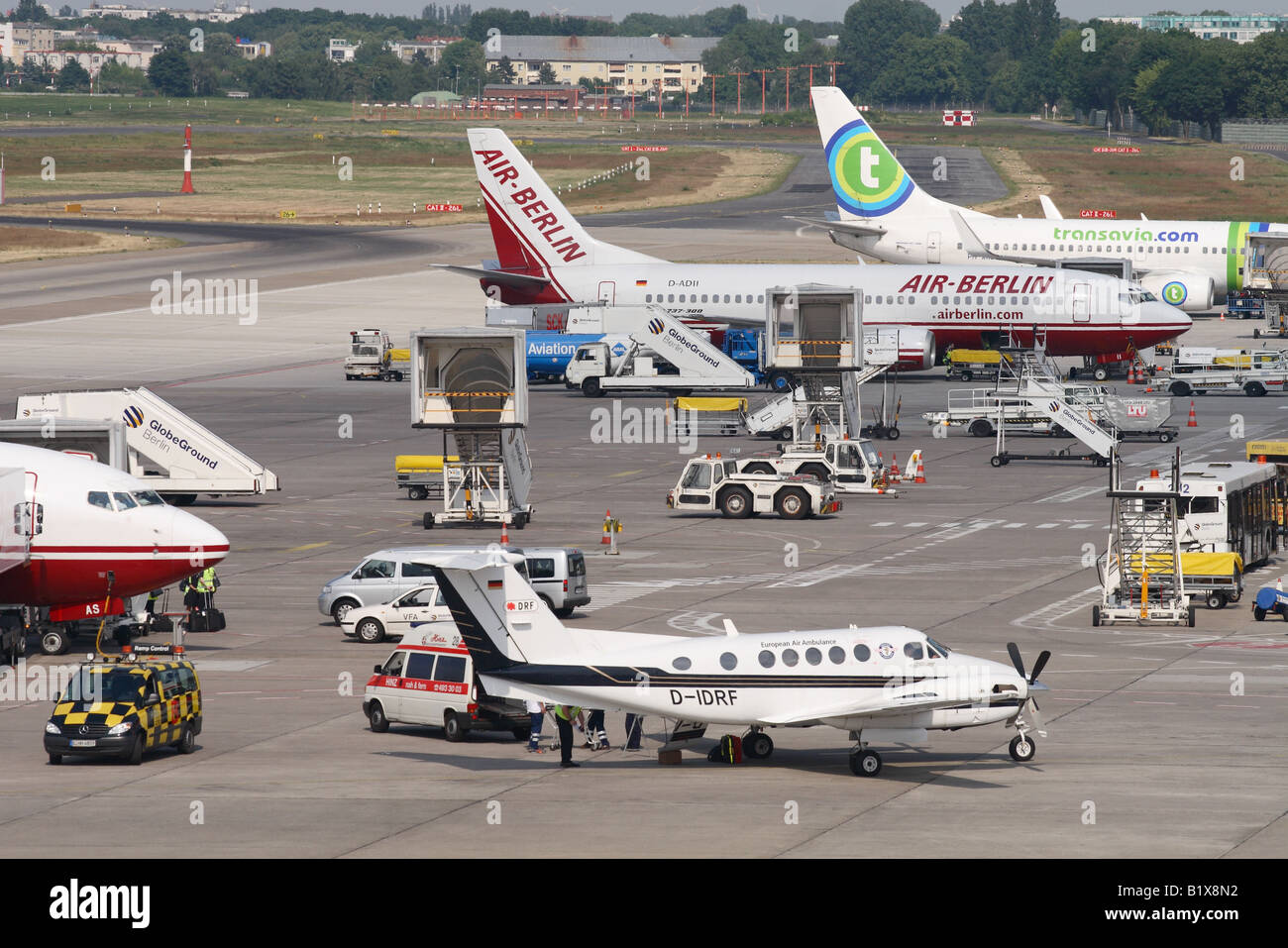 Berlin Tegel airport Germany busy ramp scene with Air Berlin Boeing 737 jet airliner aircraft and private Beech 200 aircraft Stock Photo