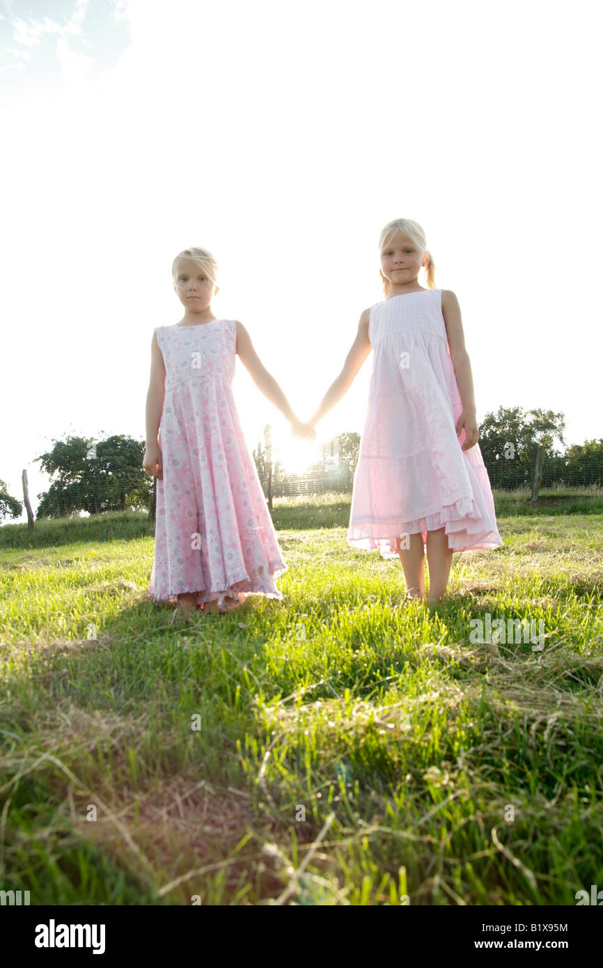 Portrait of two blonde girl friends holding hands in summer Stock Photo ...