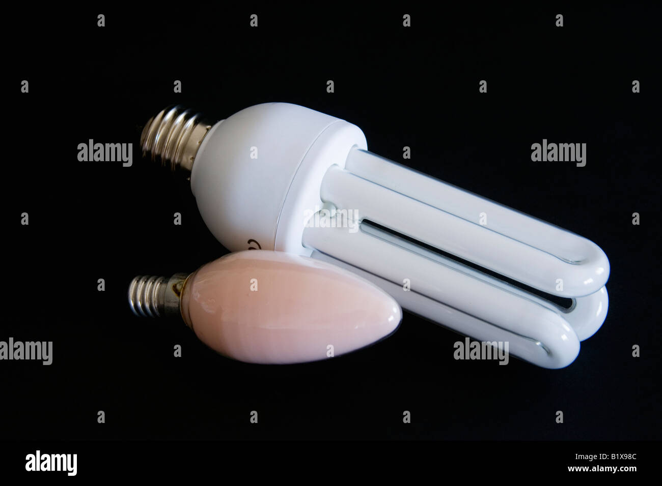 One energy saving light bulb and one traditional candle light bulb on