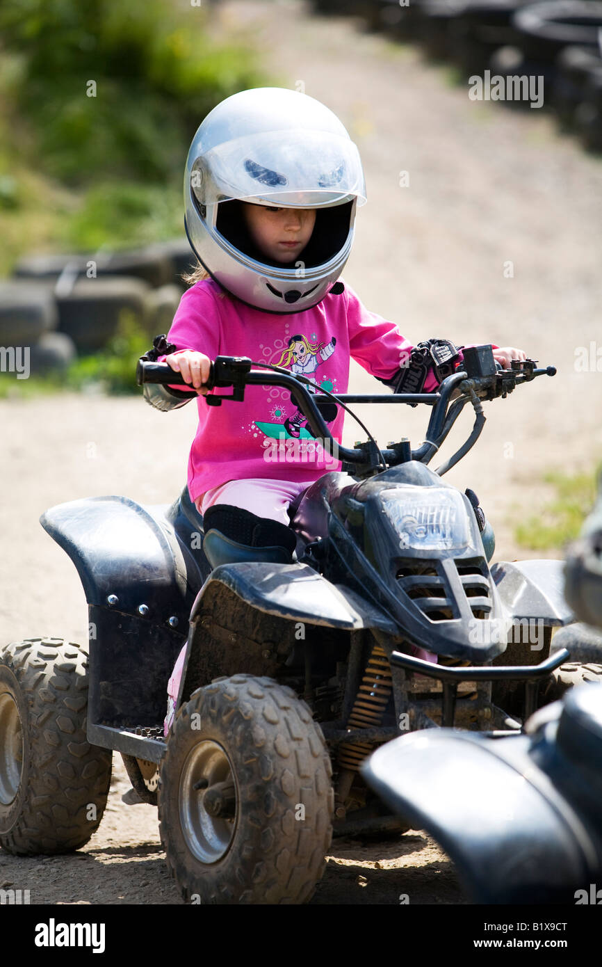 Girl riding quadbike on dirt track Stock Photo