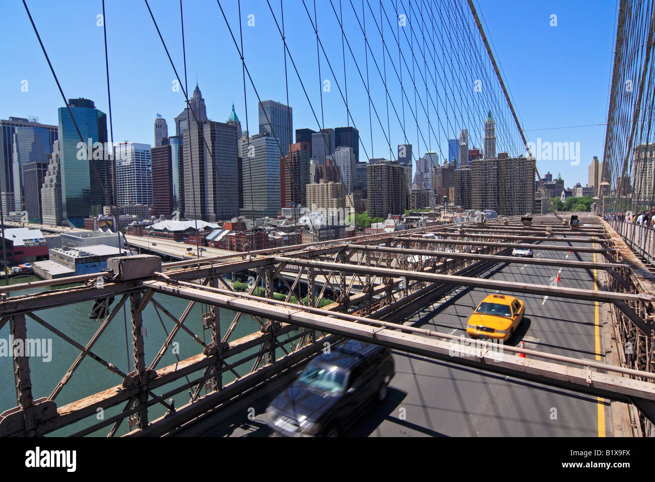Yellow taxi on Brooklyn bridge with Manhattan skyline in the background - New York City, USA Stock Photo