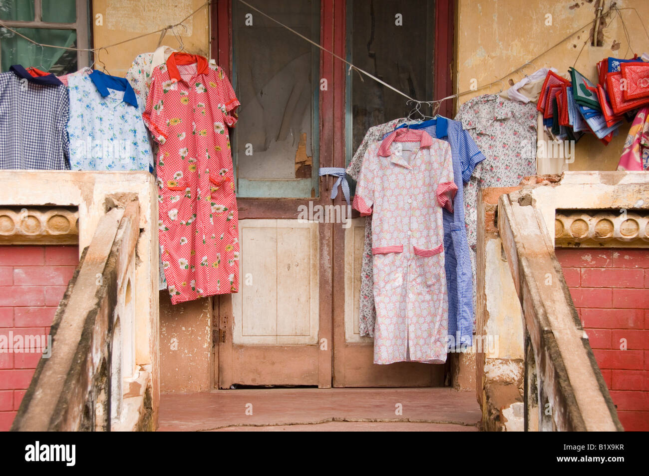 Washed clothes hanged outside on the veranda of an old deteriorated villa in Maputo, Mozambique. Stock Photo