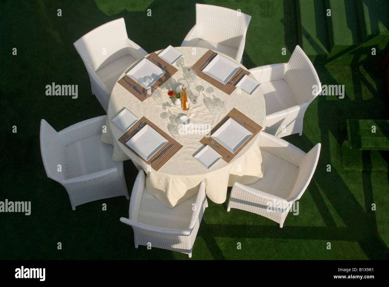 Horizontal elevated view of a round table set outside ready for dinner service at an expensive waterside restaurant Stock Photo