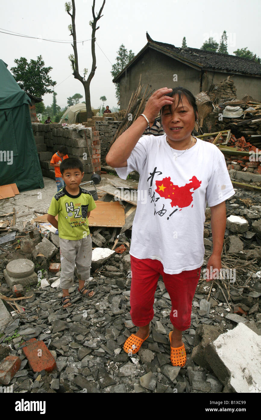 A mother stands in the remains of her house in Mianzhu following the 12th May Earthquake that devastated Sichuan Province, China Stock Photo