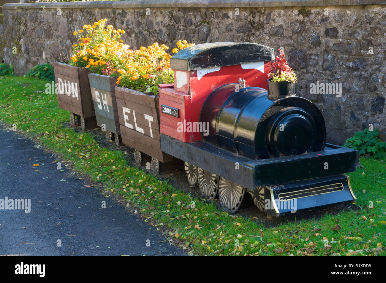Flowers blooming in the carriages of a wooden model steam train in