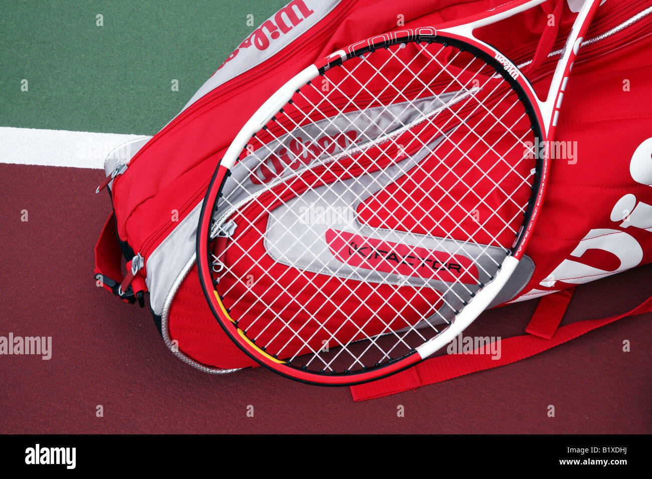 Two tennis racket bags with two tennis rackets laying crossed on top and a container of tennis