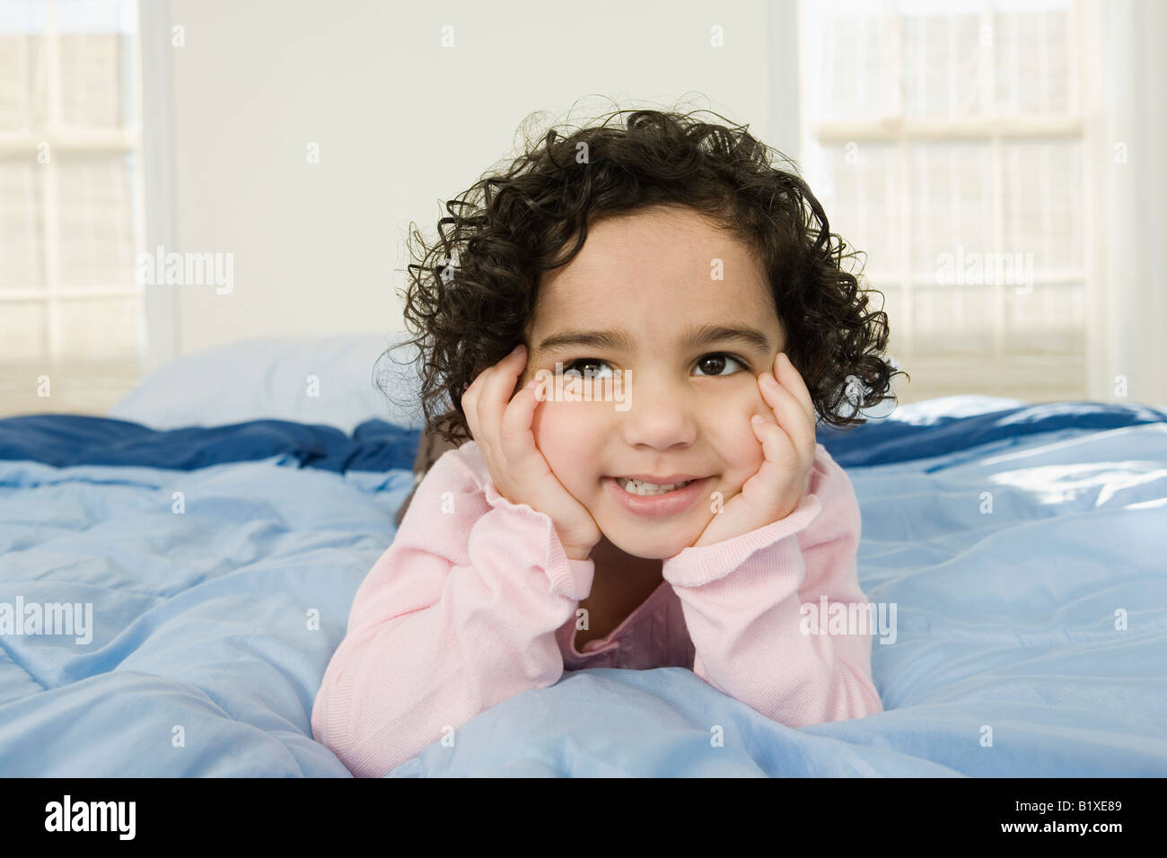 Girl lying on the bed and smiling Stock Photo - Alamy