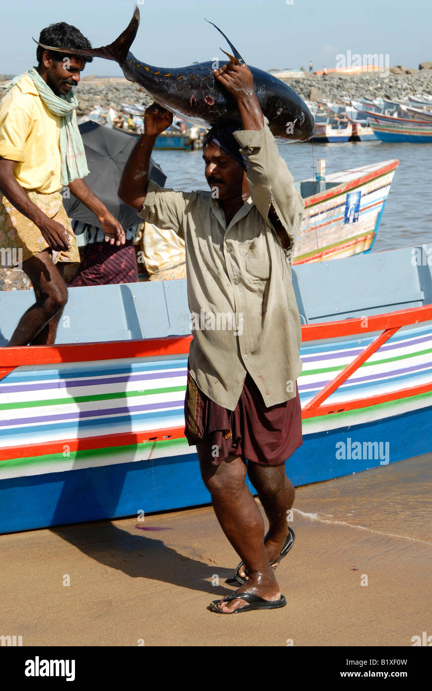A fisherman carrying a big fish catch Stock Photo - Alamy