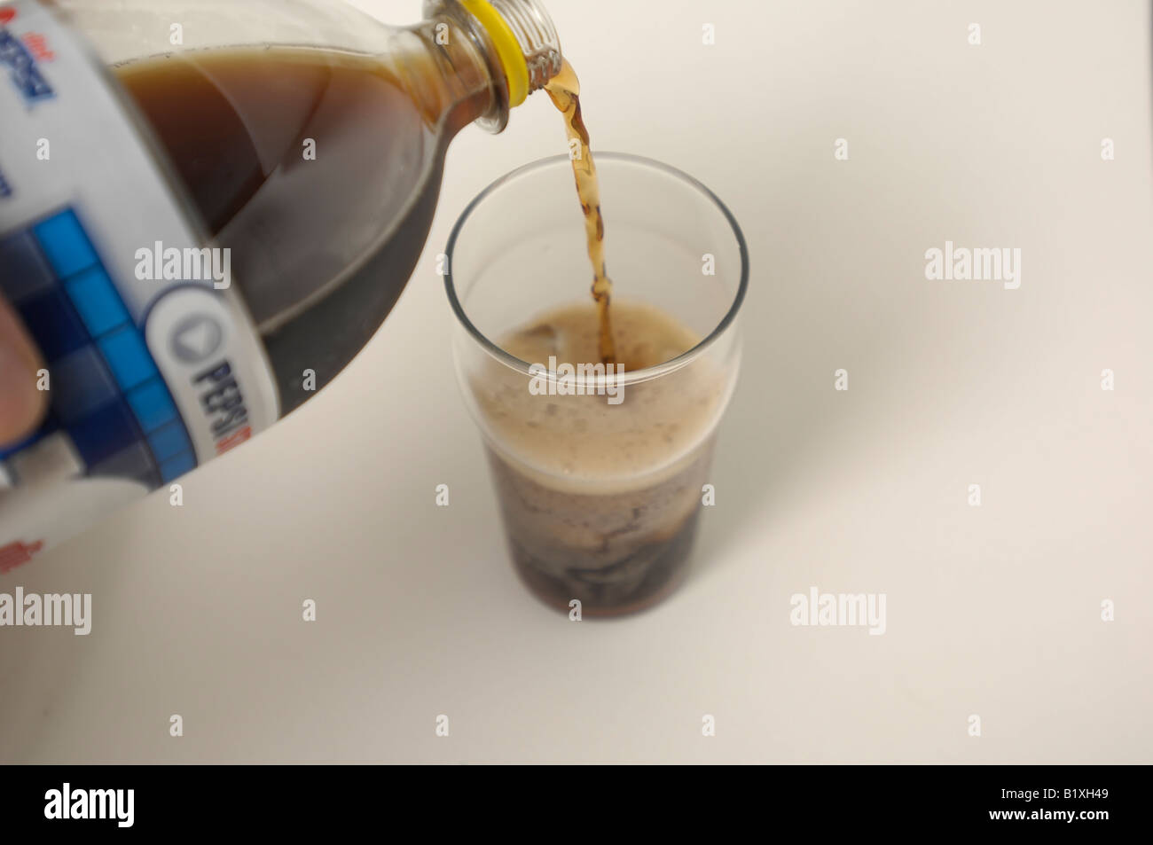 Diet Pepsi being poured into a pint glass full of ice. Stock Photo