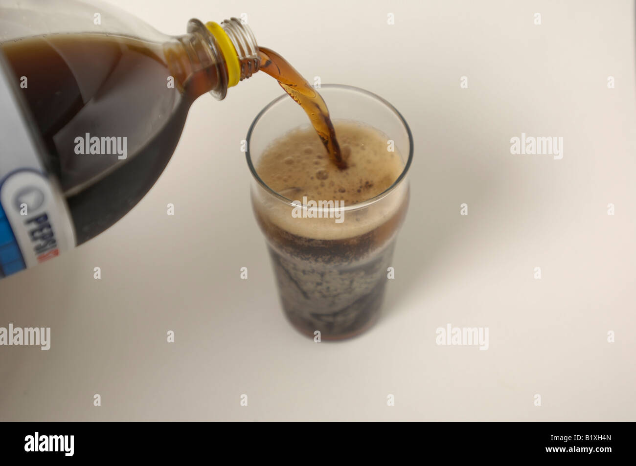 Diet Pepsi being poured into a pint glass full of ice. Stock Photo