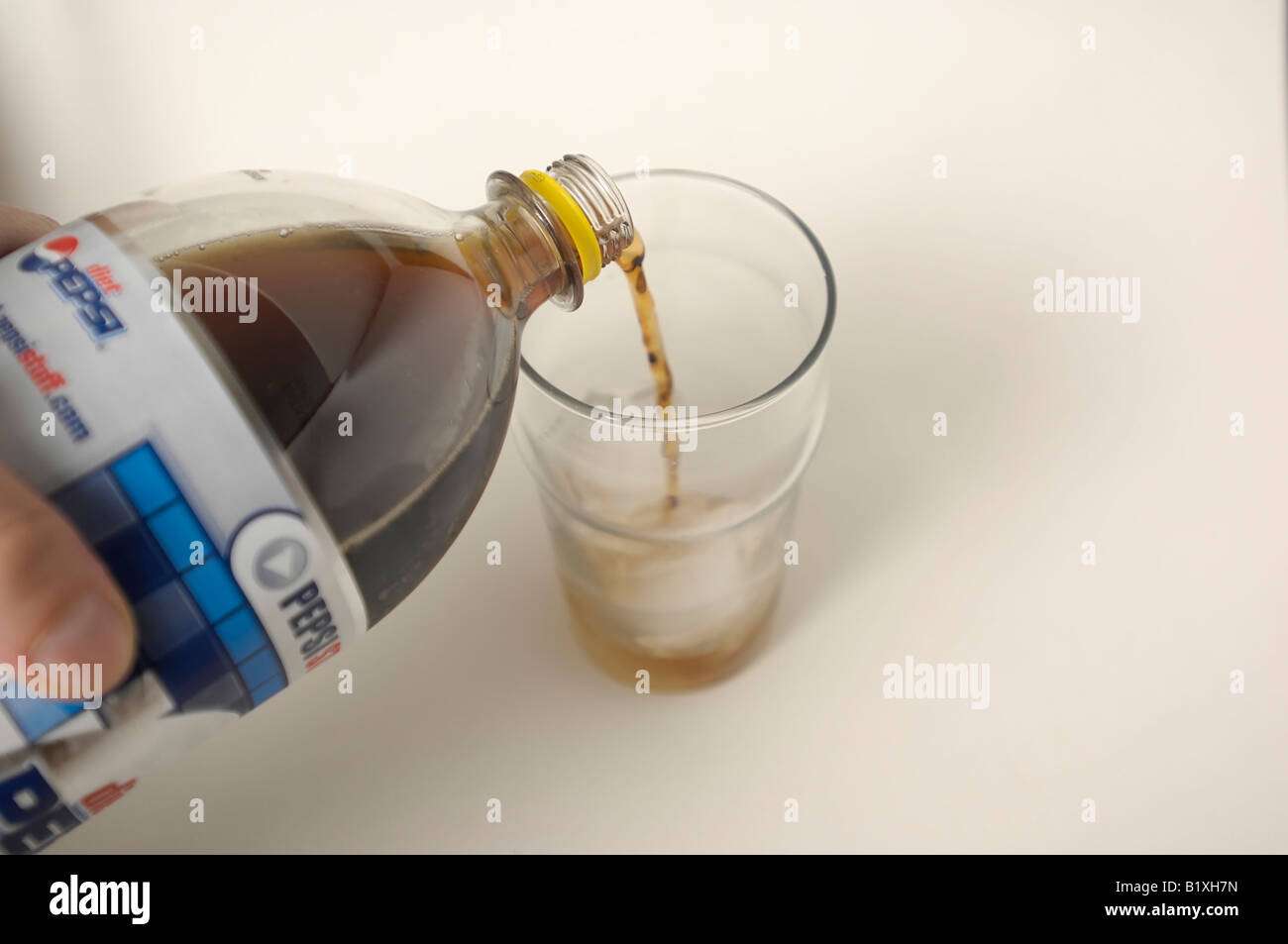Diet Pepsi being poured into a pint glass full of ice. Stock Photo