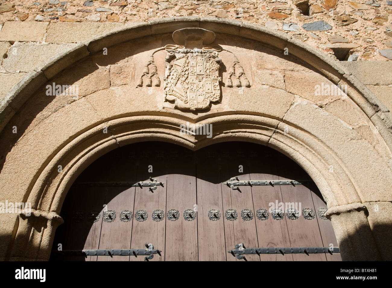 Stone coat of arms of the Bishop over a doorway, Caceres, Spain Stock Photo