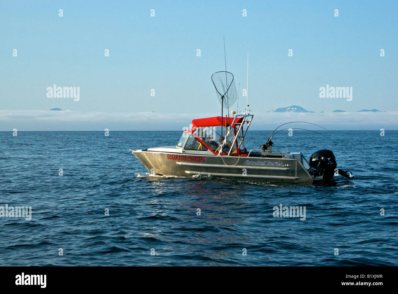 Sport fish charter boat troll fishing for salmon using downriggers and rods with single action reels Stock Photo