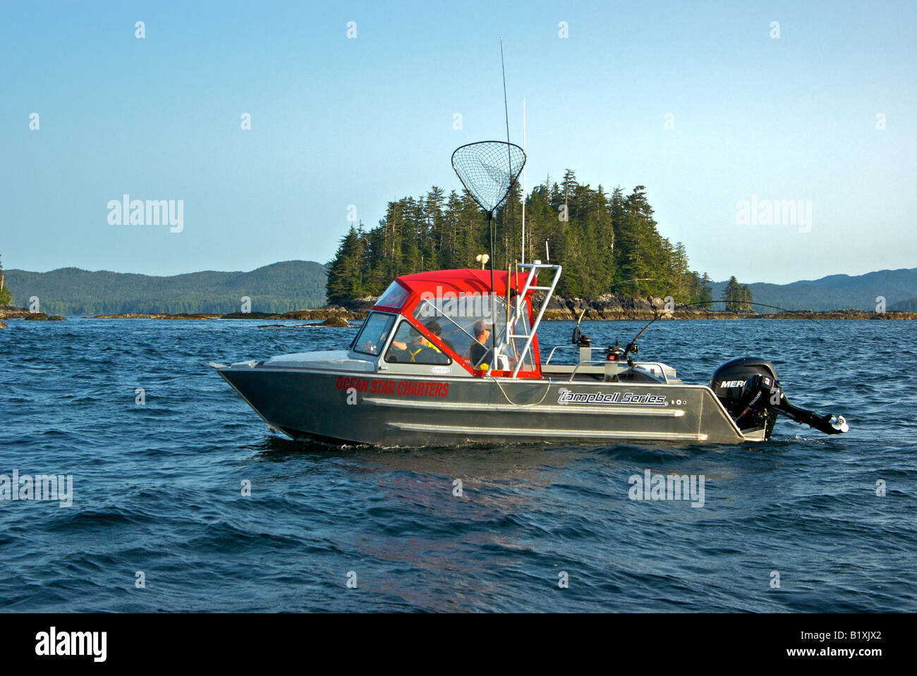 Sport fish boat troll fishing for salmon using downriggers and rods with single action reels Stock Photo