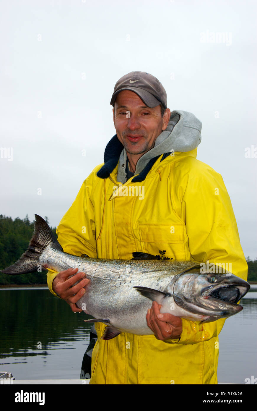 Happy smiling Asian angler holding sport caught chinook salmon