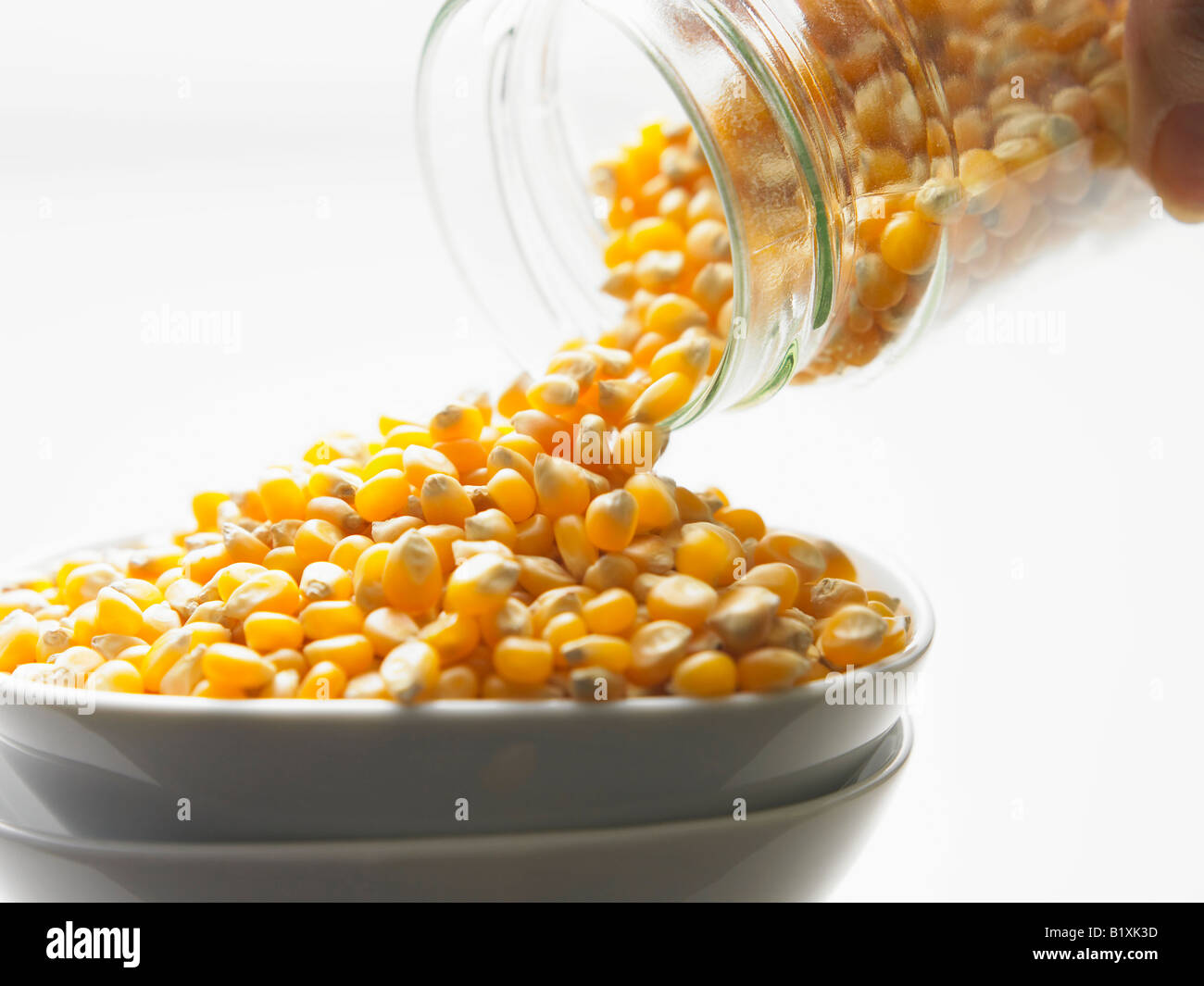 jar pouring out popcorn kernels Stock Photo - Alamy