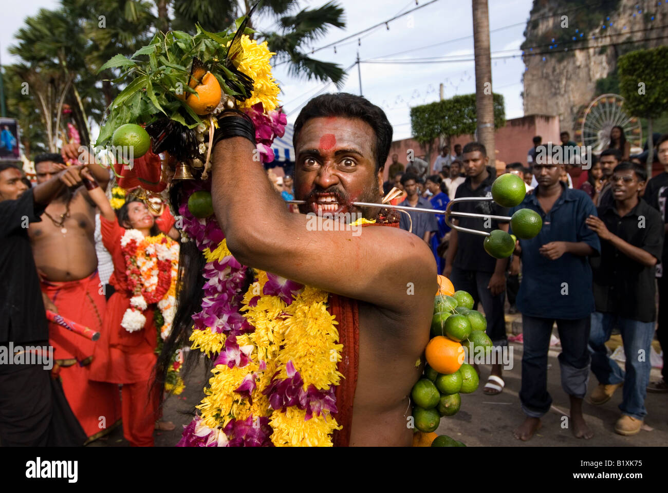 ANGRY DEVOTEE WITH SKEWER PIERCING THROUGH CHEEK AT THE ANNUAL HINDU FESTIVAL OF THAIPUSAM BATU CAVES KUALA LUMPUR MALAYSIA Stock Photo