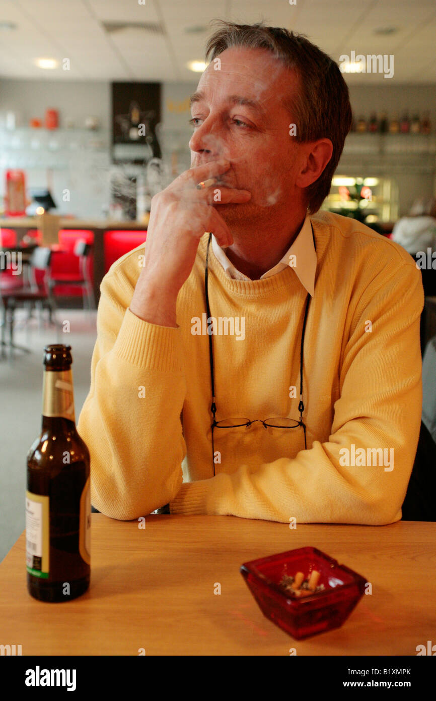 cigarette restaurant a man smoking a cigarette in a restaurant Stock Photo