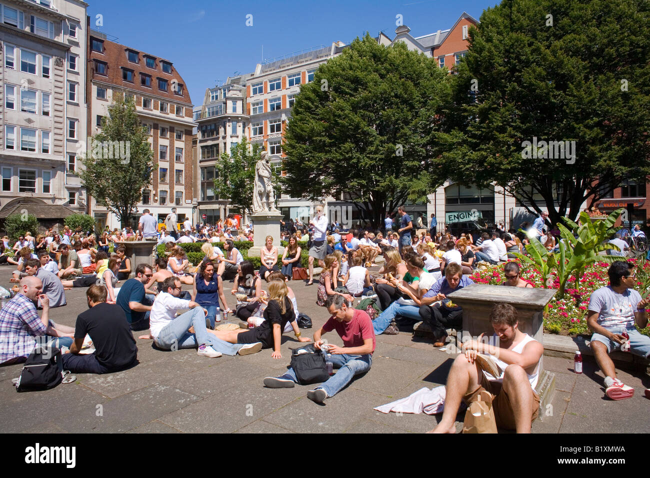Summer Lunchtime in Golden Square Soho London when everybody takes a break in the sun Stock Photo
