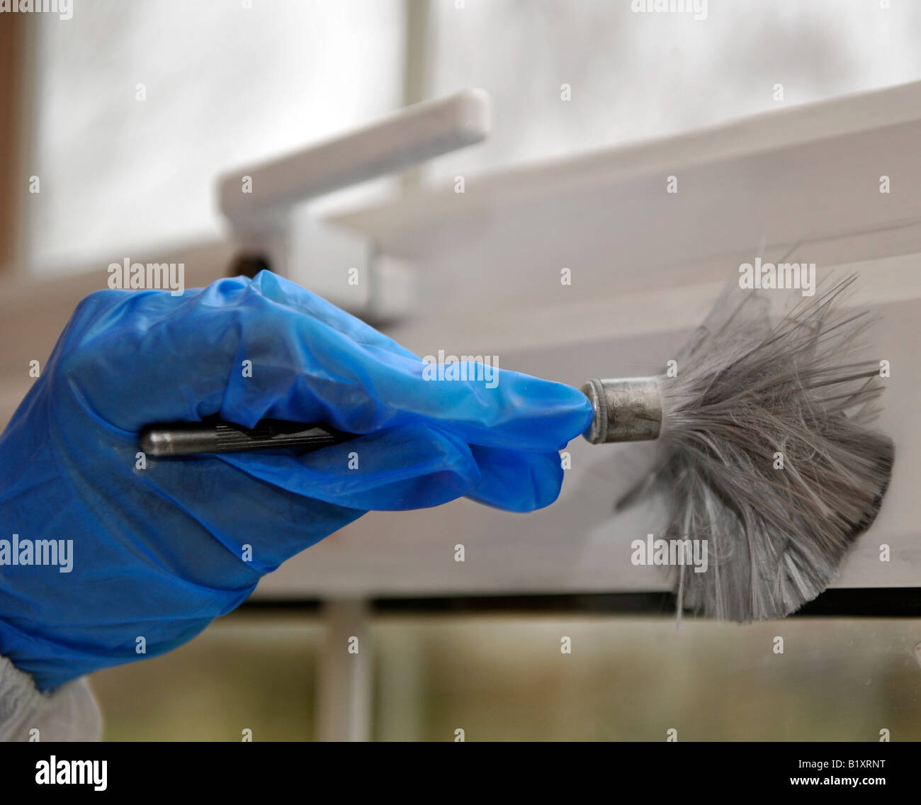 A Forensic scenes of crime officer dusts a window frame for
