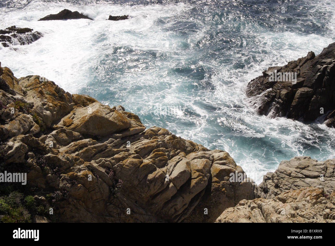 Waves splashing between rocks Stock Photo - Alamy