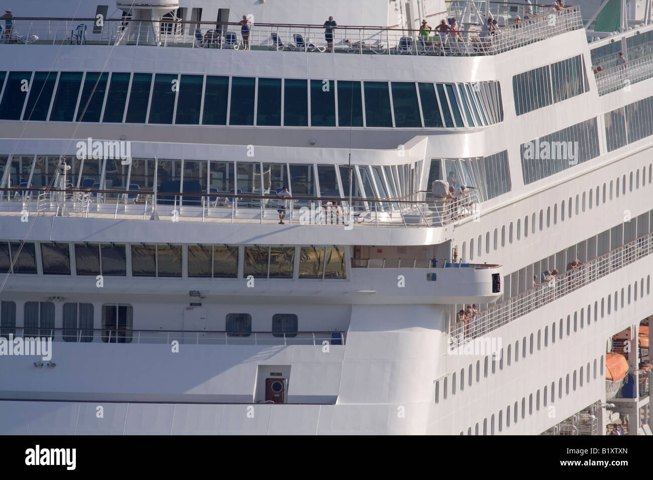 Cruise ship superstructure with passengers relaxing on board Stock Photo